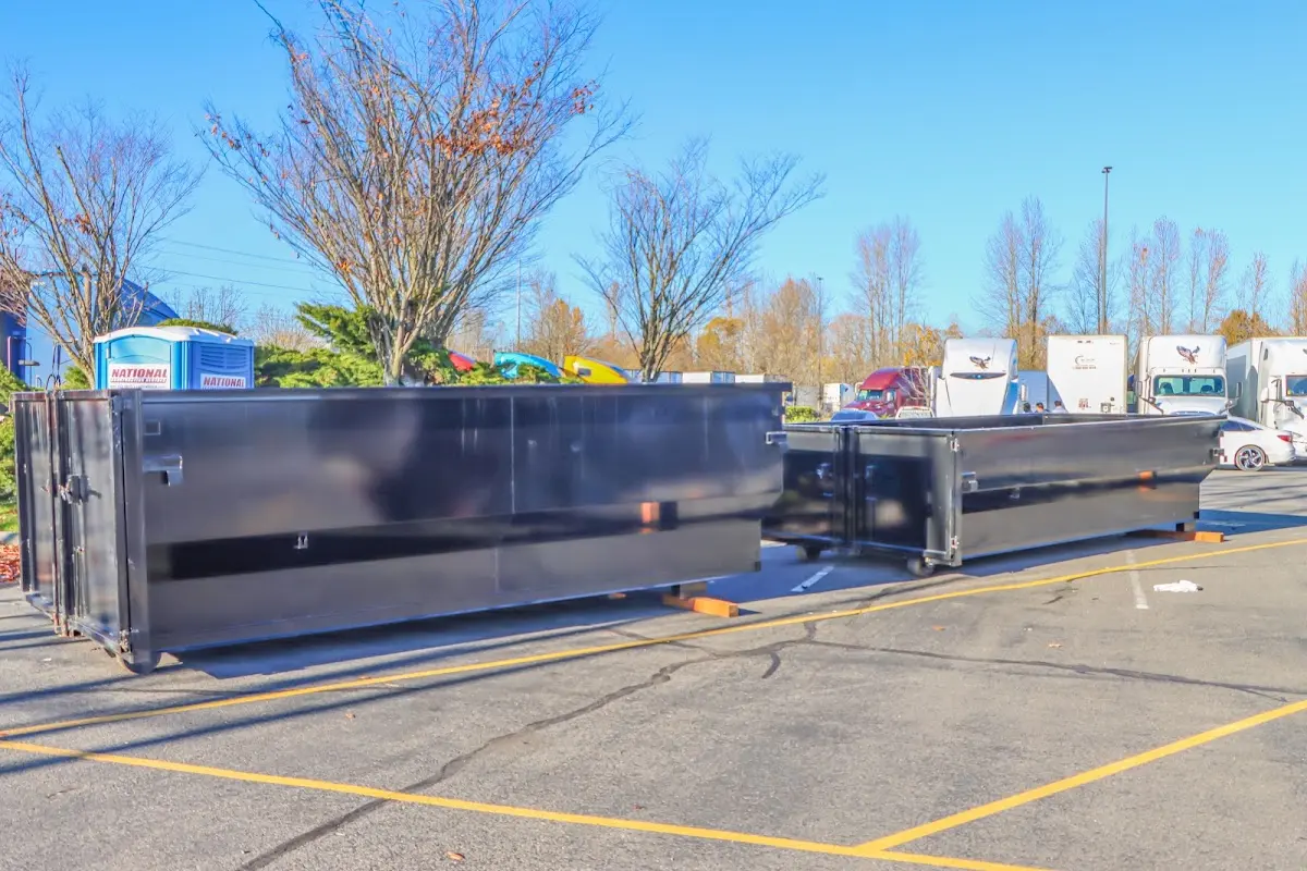 Professional dumpster rental service with roll-off container on residential driveway in East Grand Forks